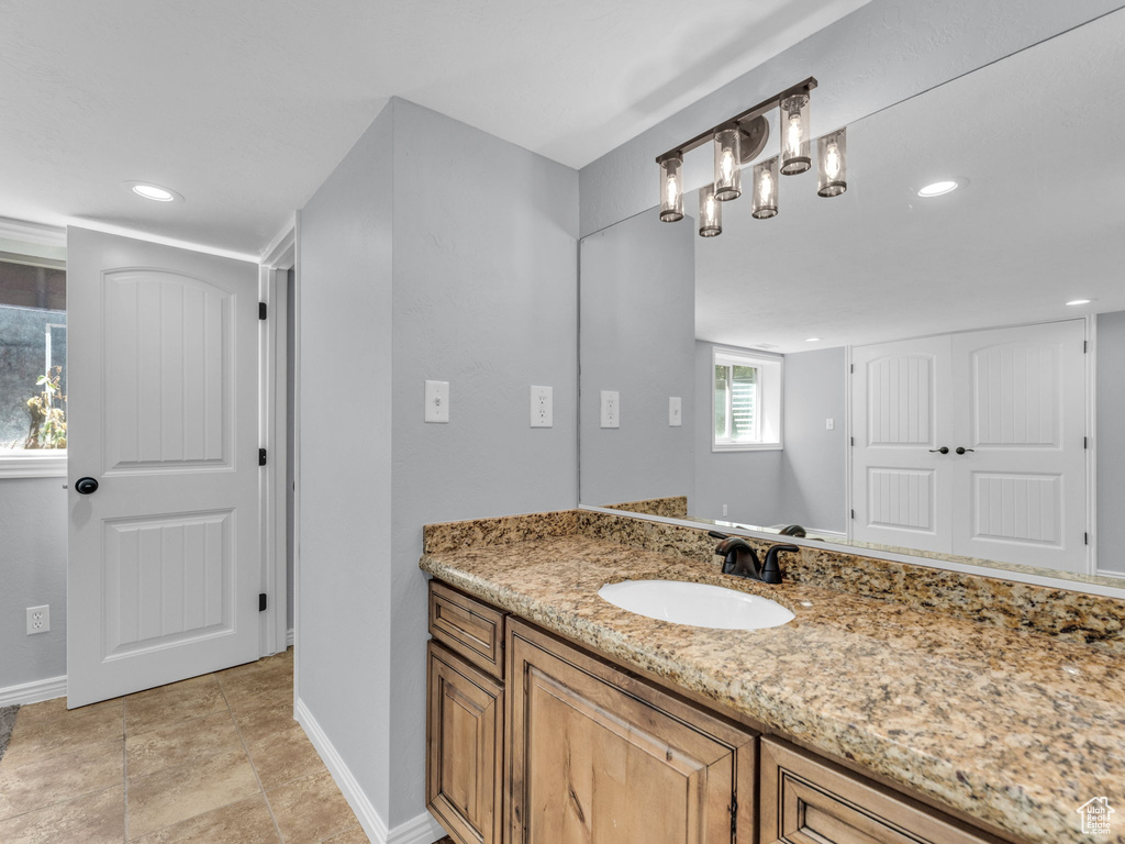 Bathroom featuring baseboards, vanity, and recessed lighting