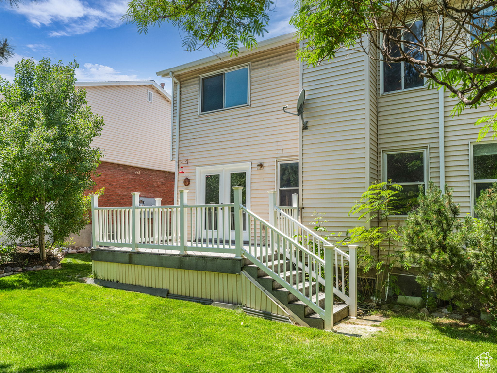 Back of house featuring a wooden deck and a yard