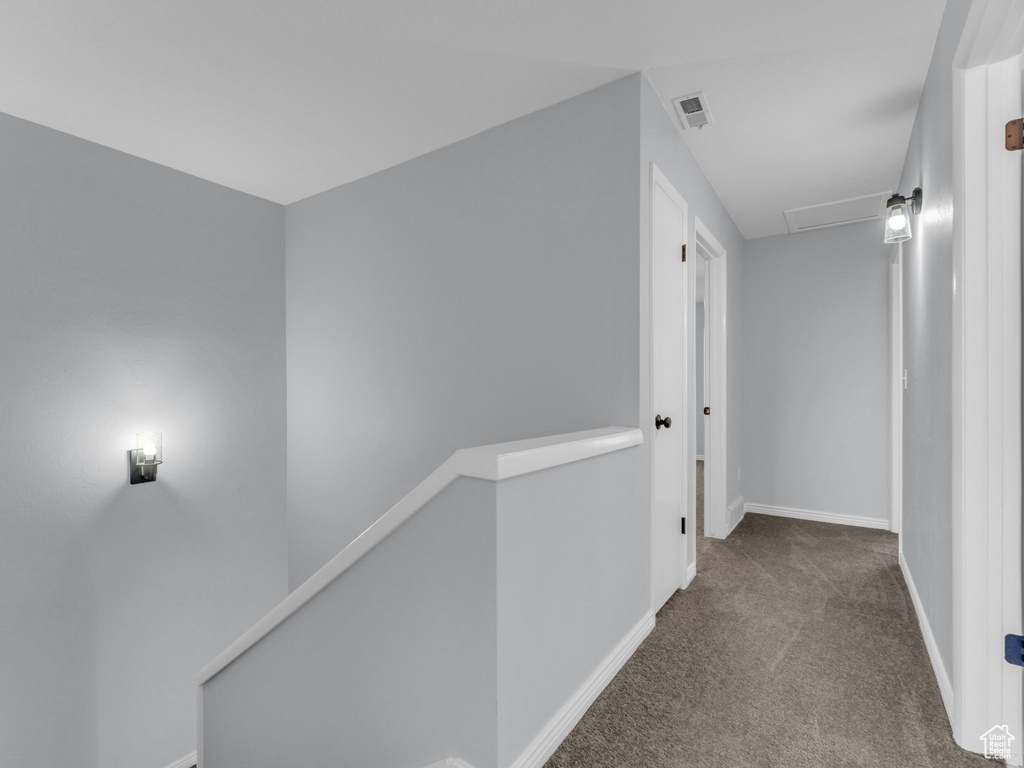 Hall with an upstairs landing, carpet floors, and baseboards
