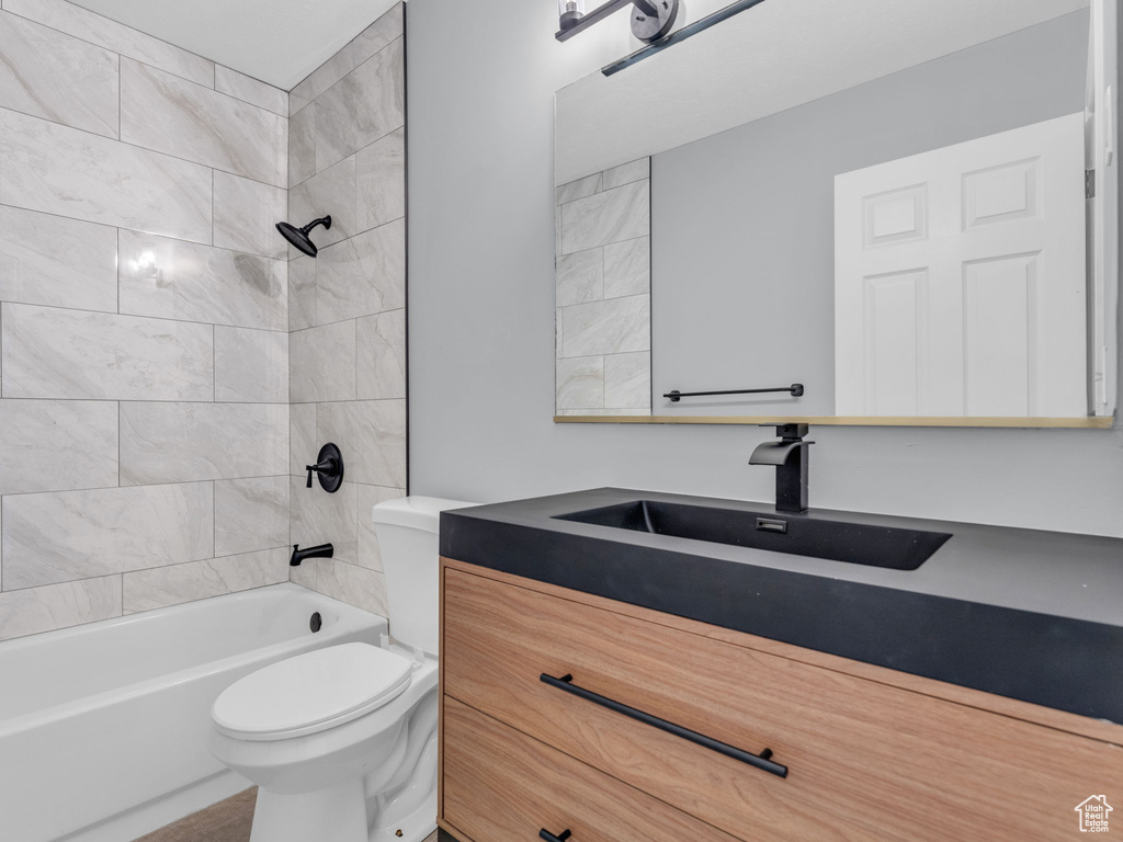 Full bath featuring toilet, vanity, and bathing tub / shower combination