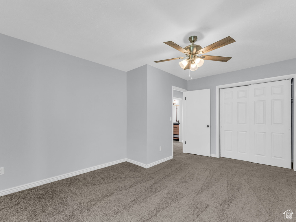 Unfurnished bedroom featuring carpet floors, baseboards, a closet, and ceiling fan