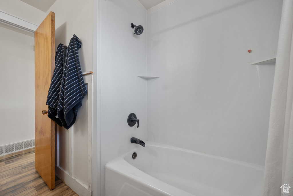 Bathroom with shower / bath combo with shower curtain and wood finished floors