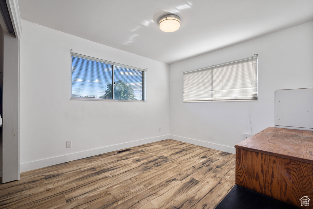 Unfurnished office with wood finished floors and baseboards