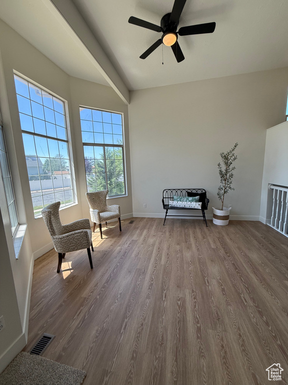 Living area with baseboards, dark wood-style flooring, and ceiling fan