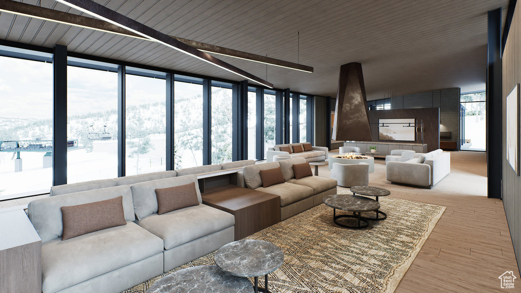 Living room with light wood-style flooring, healthy amount of natural light, floor to ceiling windows, and beamed ceiling