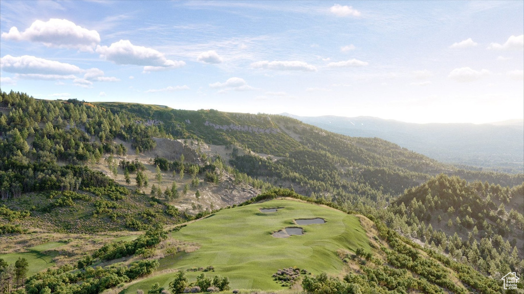 View of property location featuring a mountainous background and a local golf course