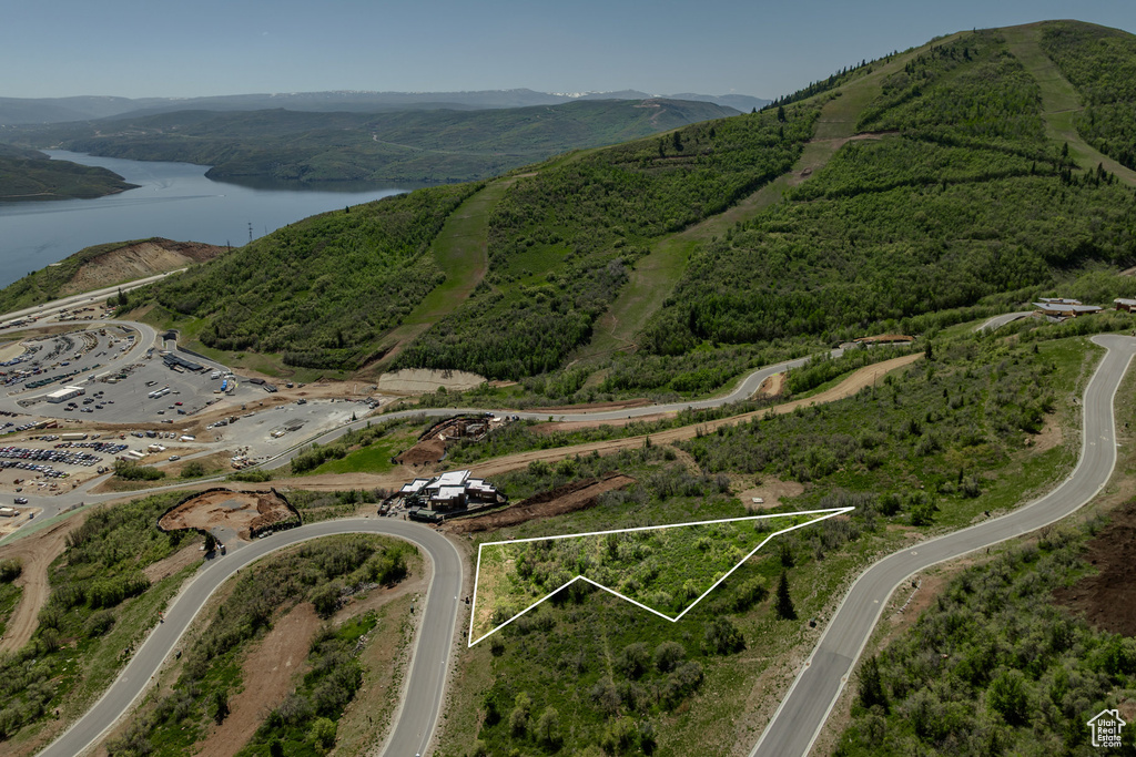 Aerial view of property and surrounding area with a water and mountain view and property parcel outlined