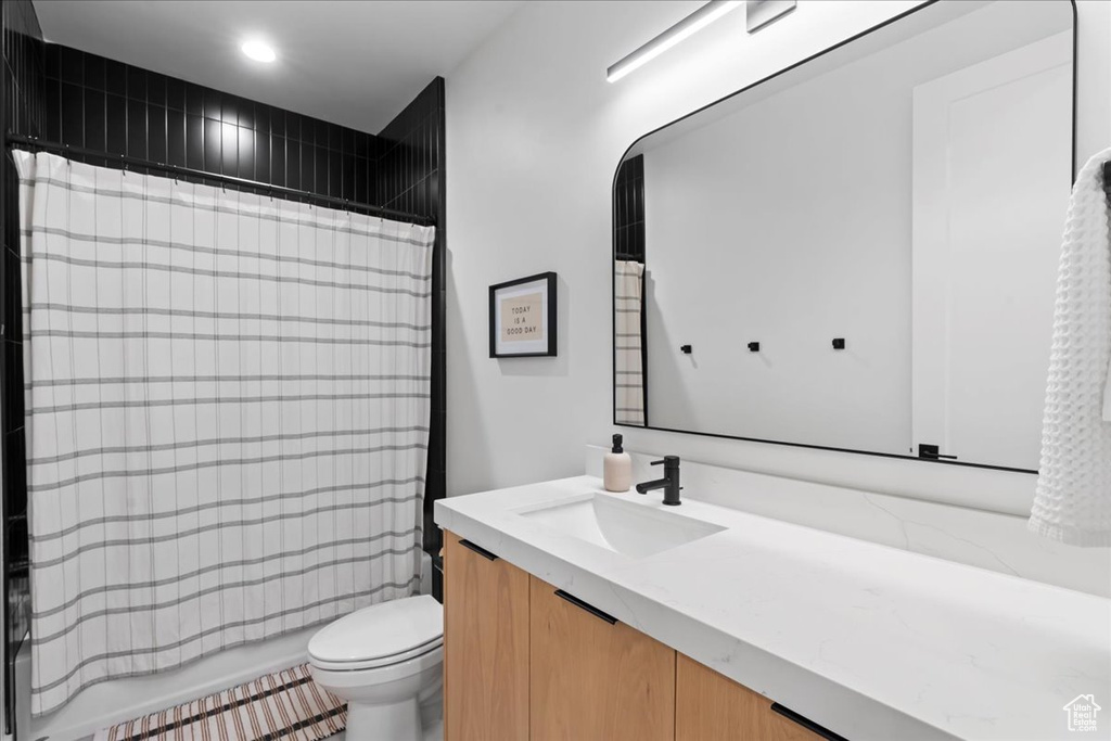 Bathroom with vanity, toilet, shower / bath combination with curtain, and recessed lighting