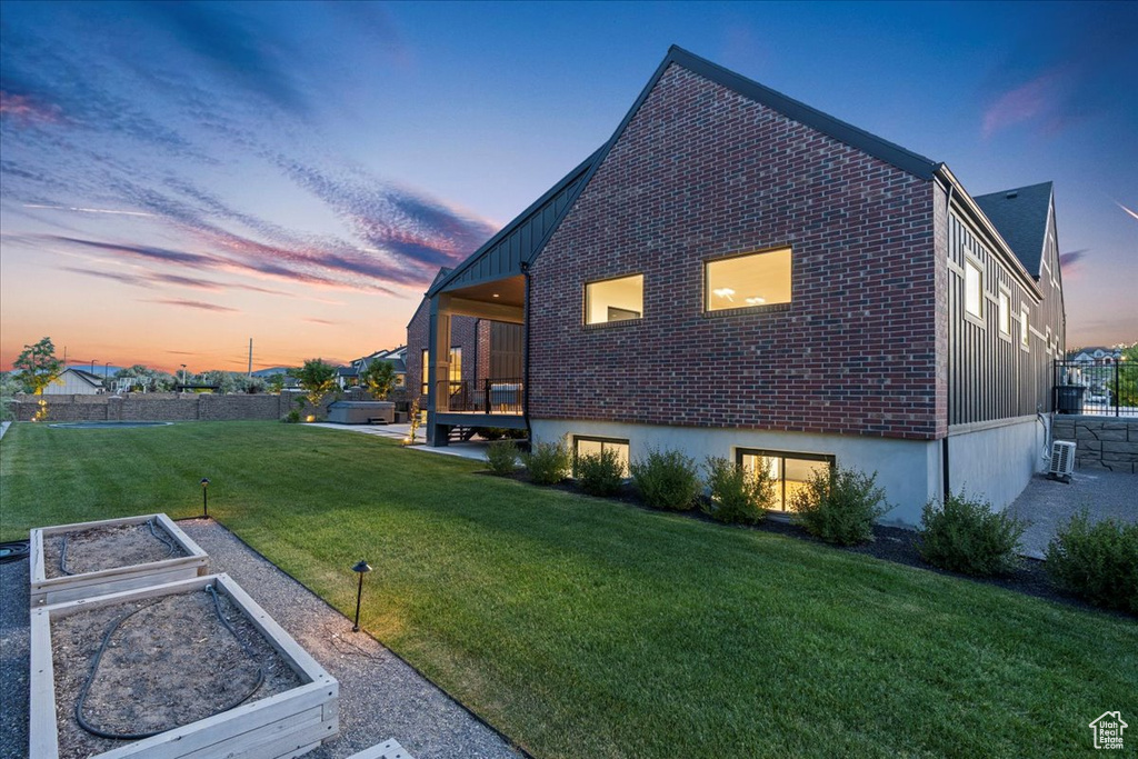 Property exterior at dusk with a garden and brick siding