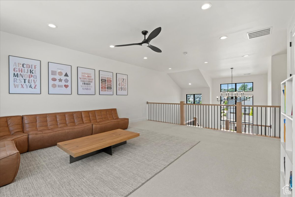 Living room featuring a ceiling fan, recessed lighting, carpet, and a chandelier