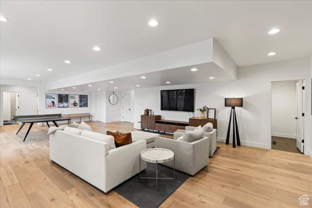 Living area with light wood finished floors, baseboards, and recessed lighting