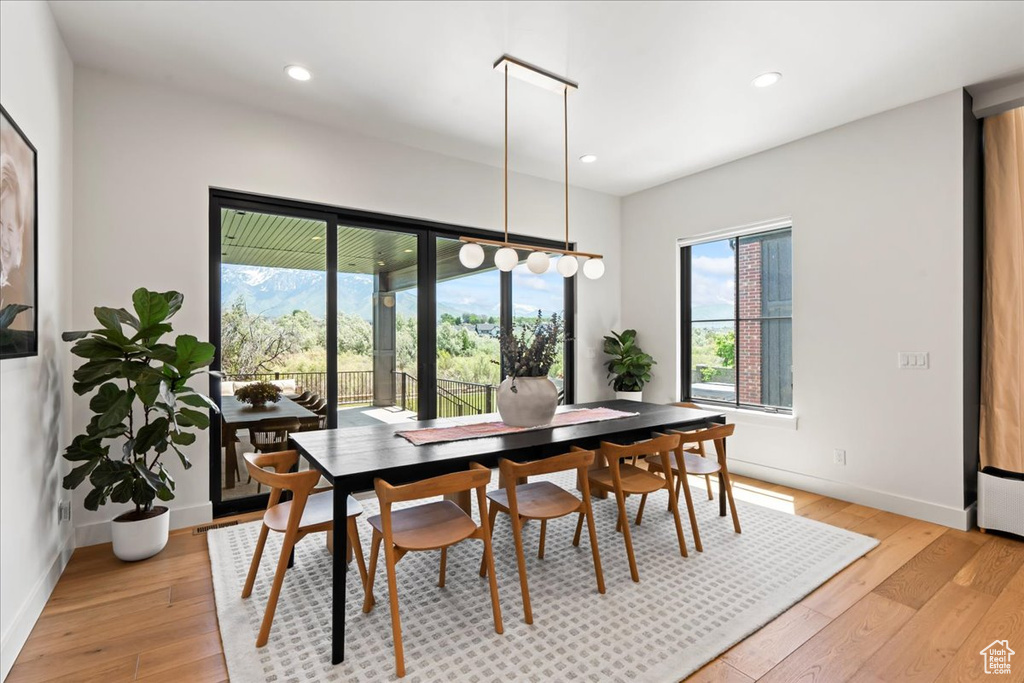 Dining area with light wood finished floors, baseboards, and recessed lighting