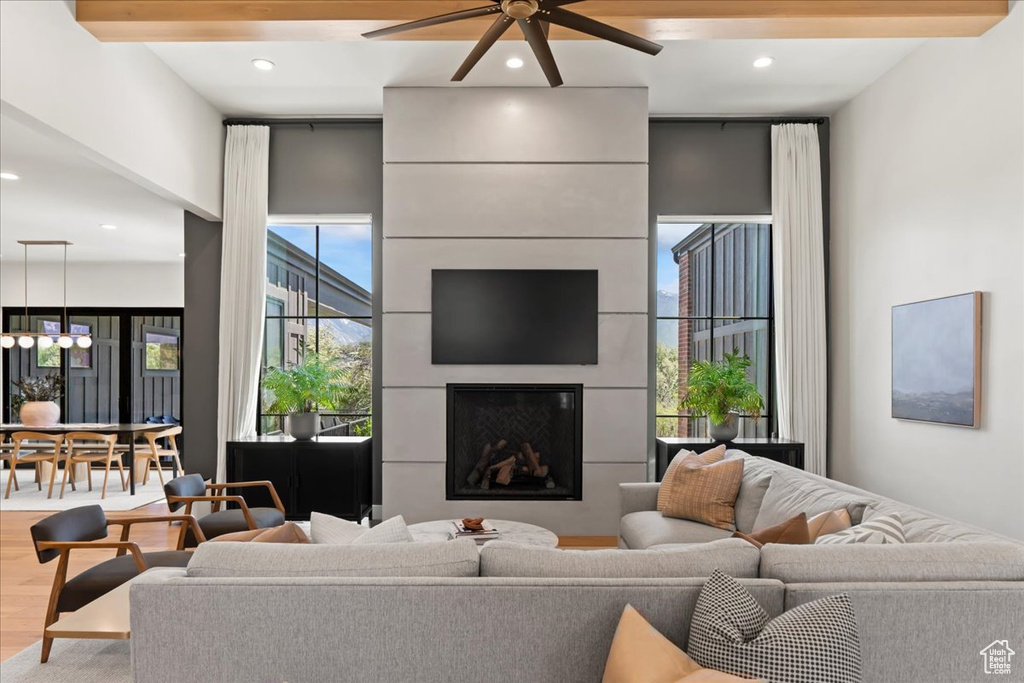 Living area with ceiling fan, a fireplace, wood finished floors, and recessed lighting