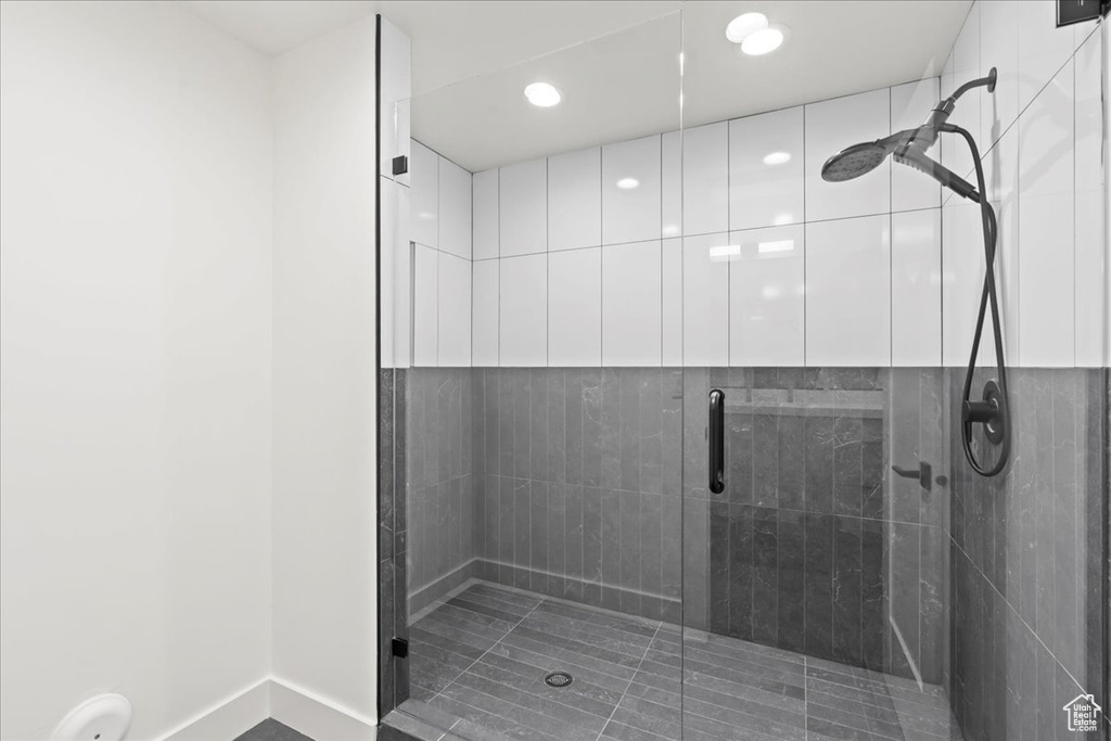Full bath with a shower stall, recessed lighting, and baseboards