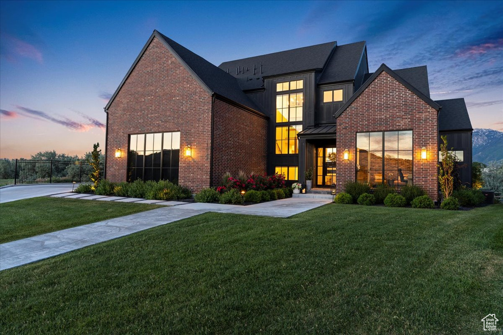 View of front facade with brick siding, a standing seam roof, and metal roof