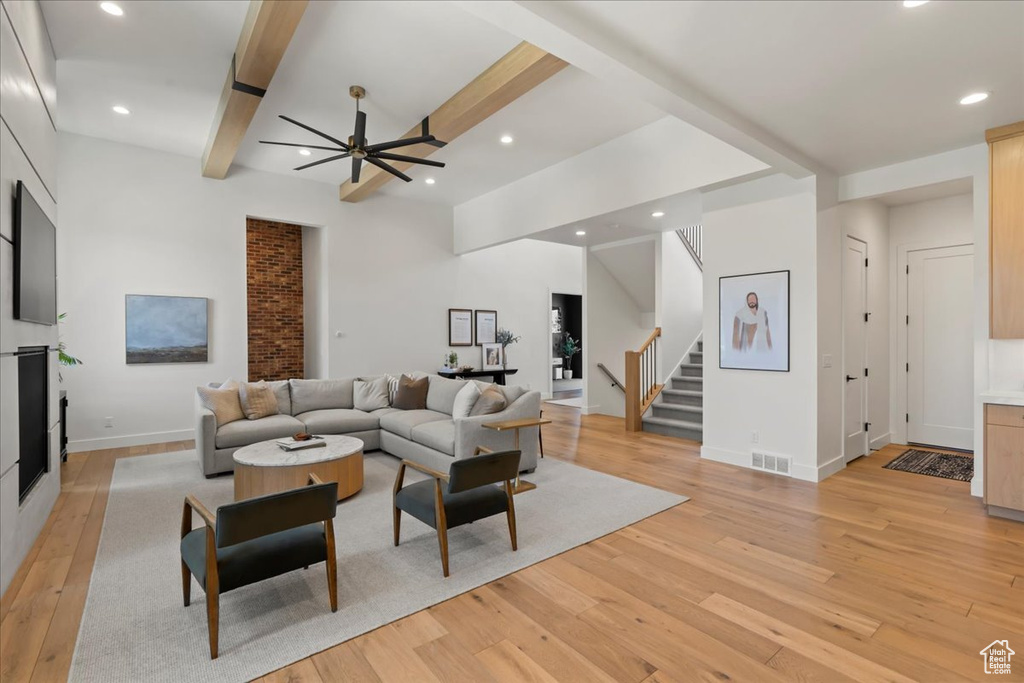 Living room featuring light wood-type flooring, stairs, a ceiling fan, recessed lighting, and baseboards