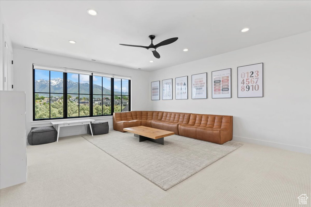 Carpeted living area with recessed lighting and a ceiling fan