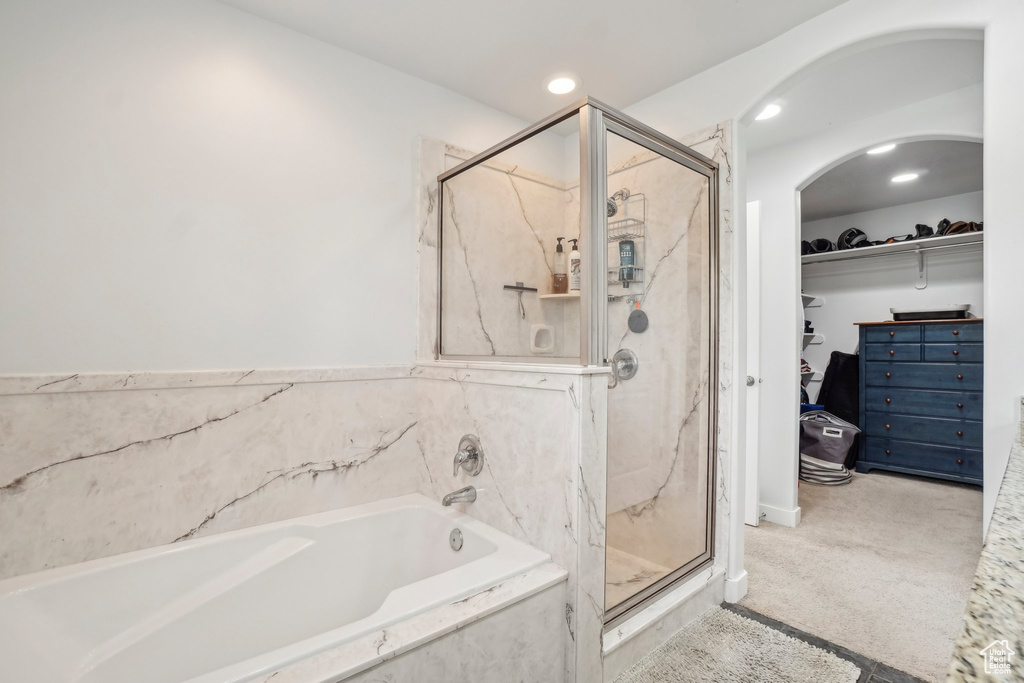 Full bath with a bath, a marble finish shower, a spacious closet, and recessed lighting