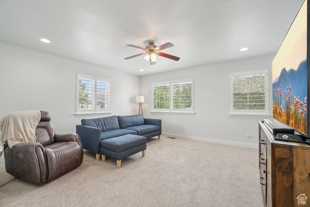 Living area featuring light carpet, a ceiling fan, recessed lighting, and baseboards