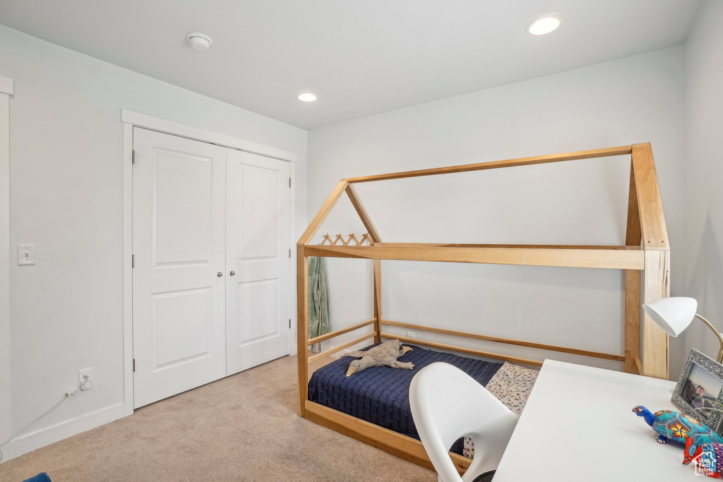 Carpeted bedroom featuring recessed lighting and a closet