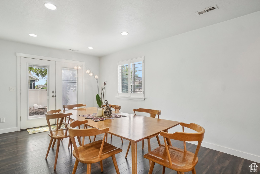 Dining area with healthy amount of natural light, baseboards, recessed lighting, and dark wood-style floors