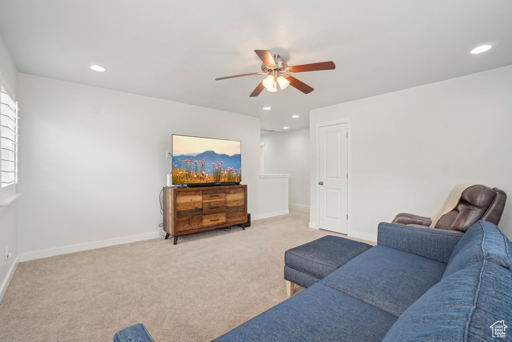 Living area featuring a ceiling fan, recessed lighting, baseboards, and light colored carpet