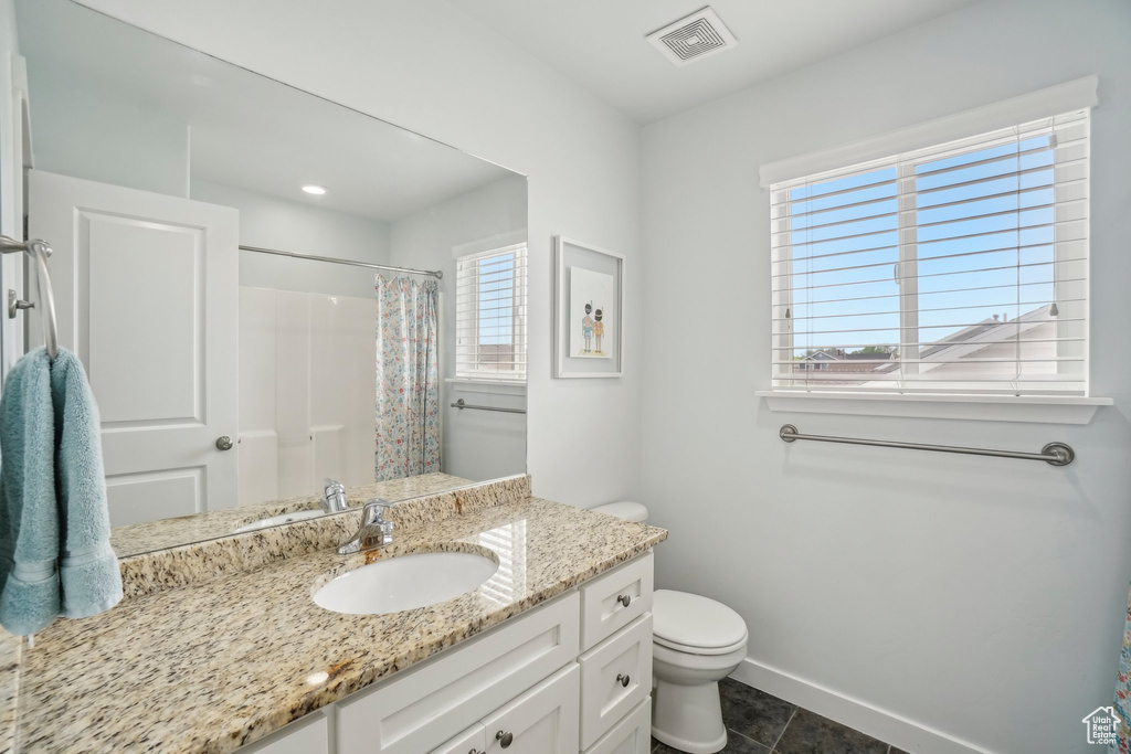 Full bathroom featuring toilet, vanity, a shower with shower curtain, tile patterned flooring, and baseboards