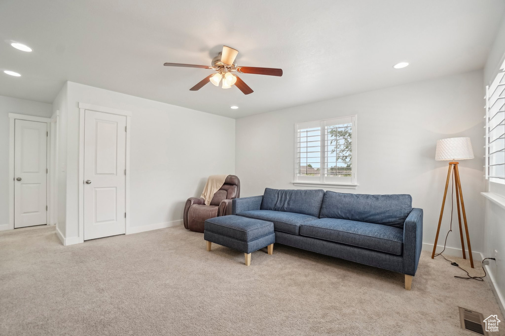 Living area with a ceiling fan, light carpet, recessed lighting, and baseboards