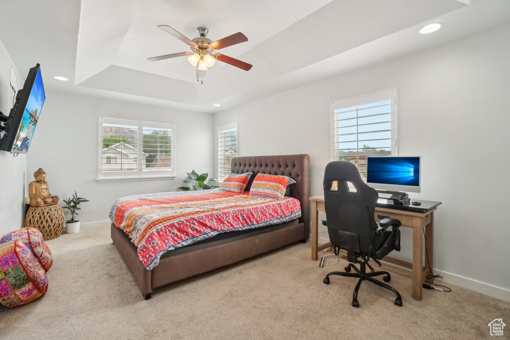 Carpeted bedroom with a raised ceiling, recessed lighting, a desk, baseboards, and ceiling fan
