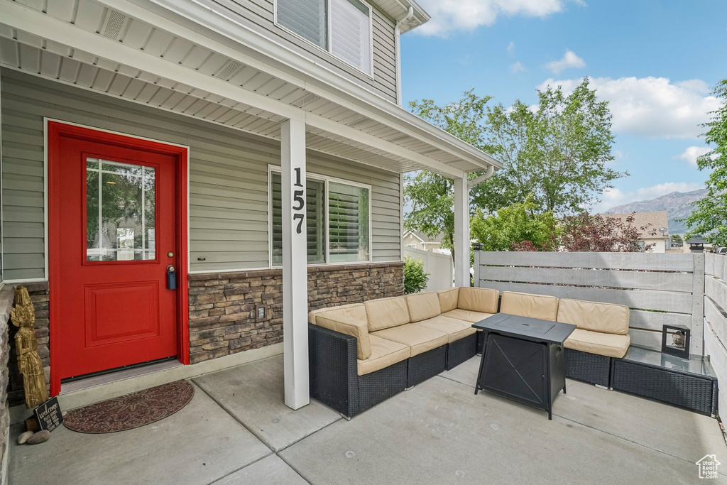 Property entrance with outdoor lounge area, stone siding, a mountain view, and covered porch