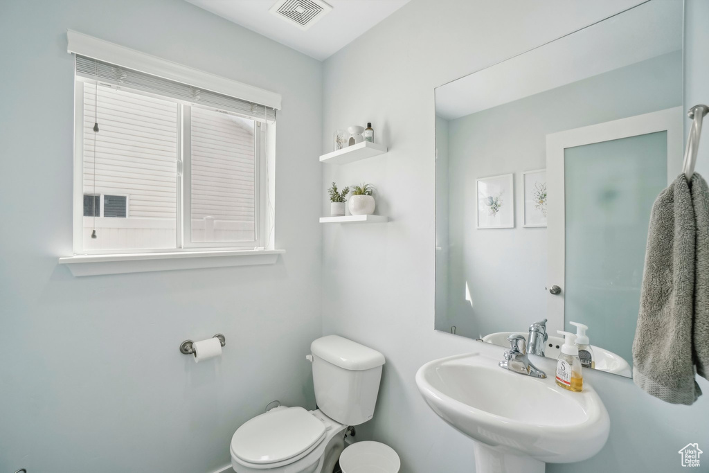 Half bath featuring toilet and a sink