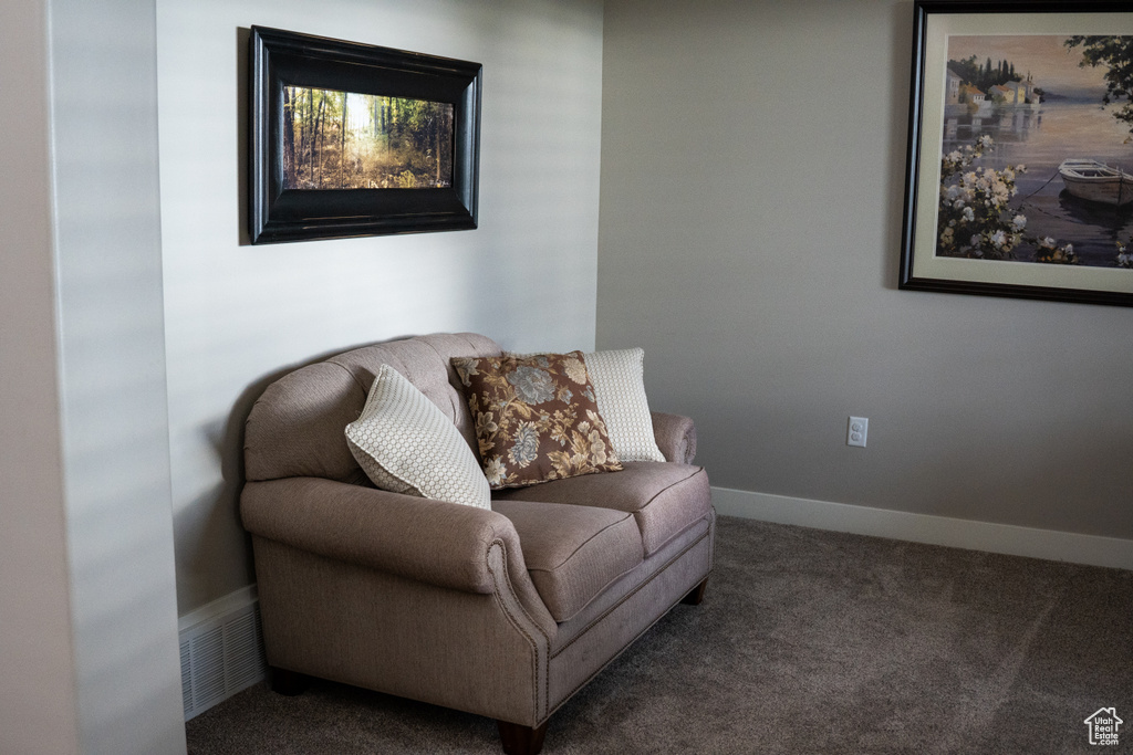 Living area featuring carpet flooring and baseboards