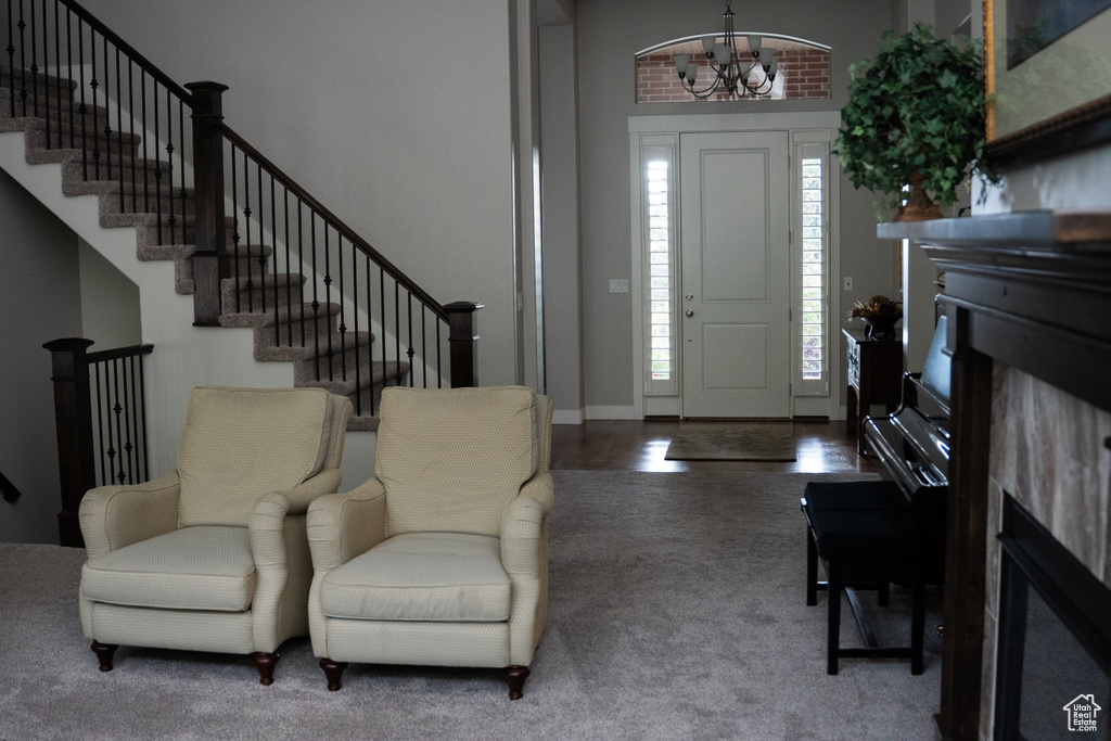 Entryway with a chandelier, stairs, and carpet floors