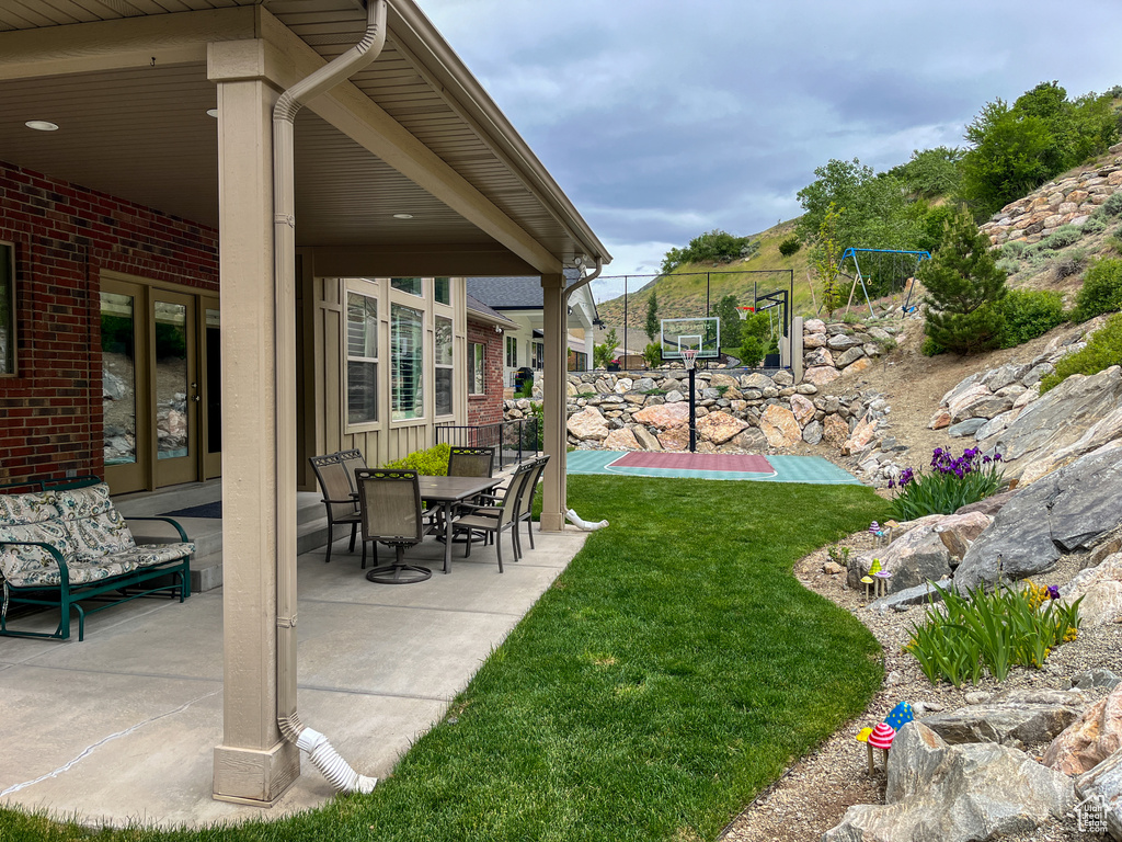 View of grassy yard with a patio area