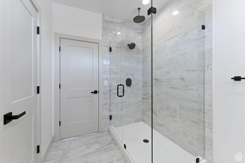 Bathroom featuring a shower stall and marble finish floors