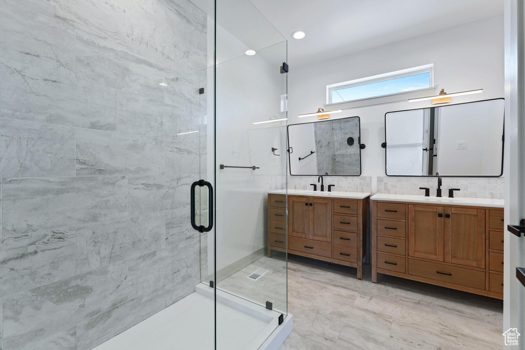 Bathroom featuring a shower stall, vanity, and marble finish floors