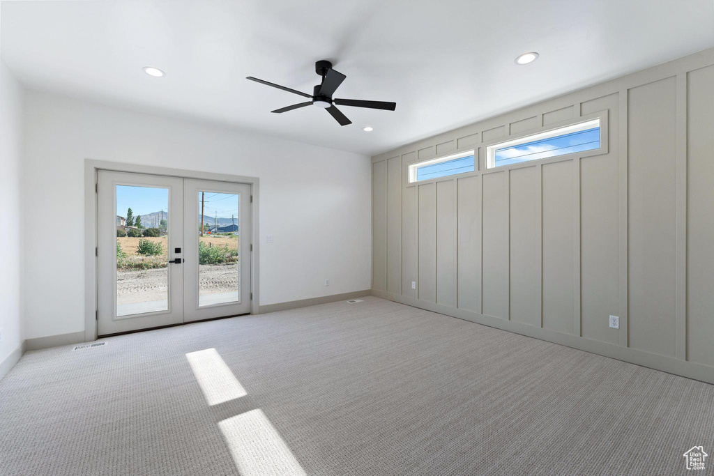 Empty room featuring light colored carpet, a ceiling fan, recessed lighting, french doors, and baseboards