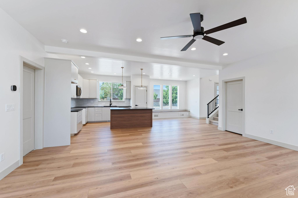Kitchen featuring open floor plan, recessed lighting, light wood finished floors, backsplash, and a kitchen island