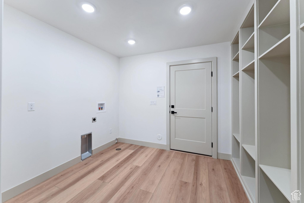 Laundry room featuring hookup for an electric dryer, washer hookup, light wood finished floors, recessed lighting, and baseboards