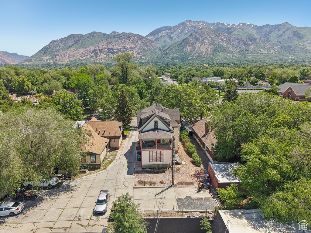 Aerial view of property and surrounding area featuring a mountain backdrop