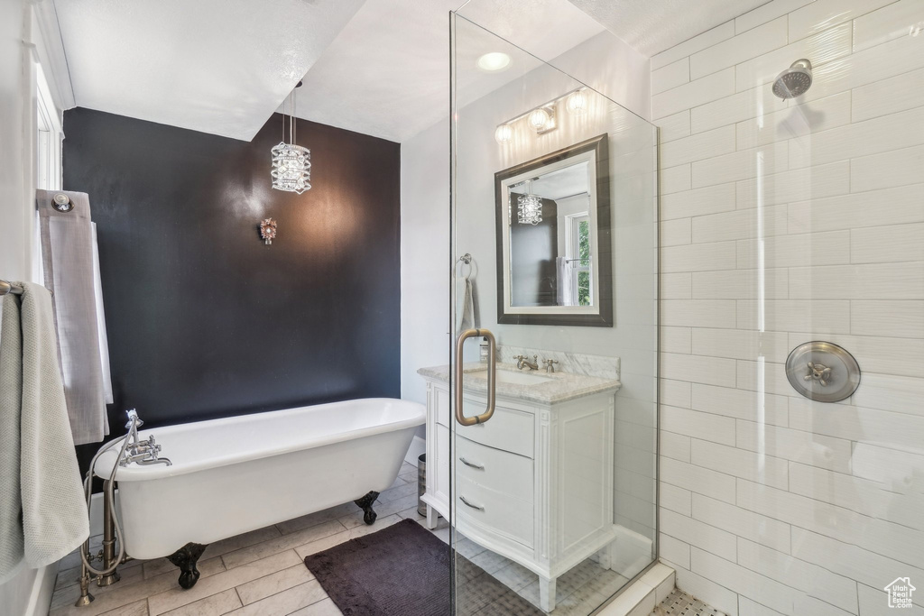 Full bath with a freestanding tub, vanity, and tiled shower