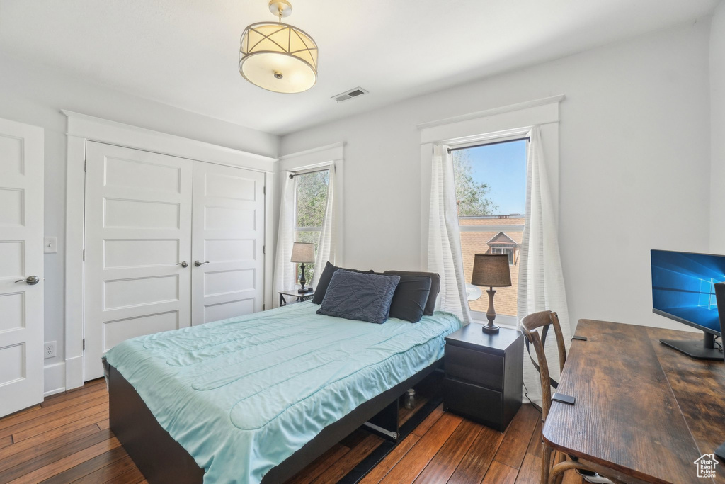 Bedroom featuring dark wood-type flooring and a closet