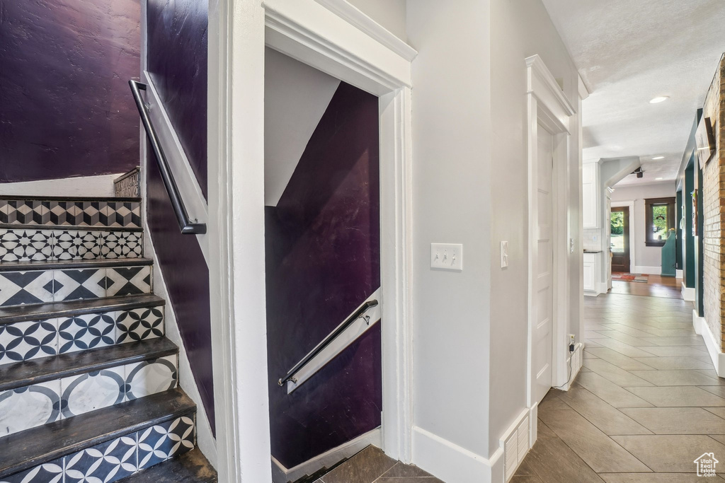 Staircase with baseboards, tile patterned flooring, and recessed lighting