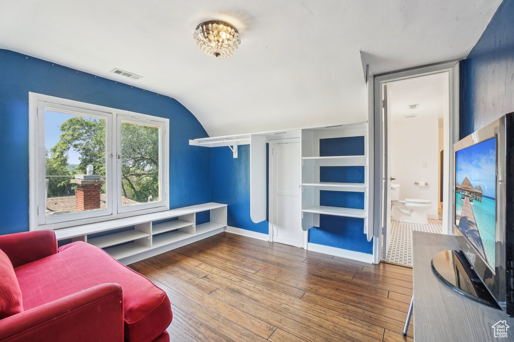 Living room with hardwood / wood-style flooring and vaulted ceiling