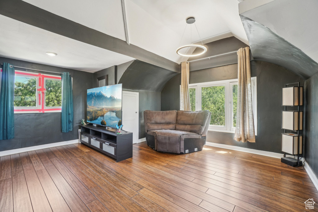 Living room featuring hardwood / wood-style flooring, healthy amount of natural light, vaulted ceiling, and baseboards