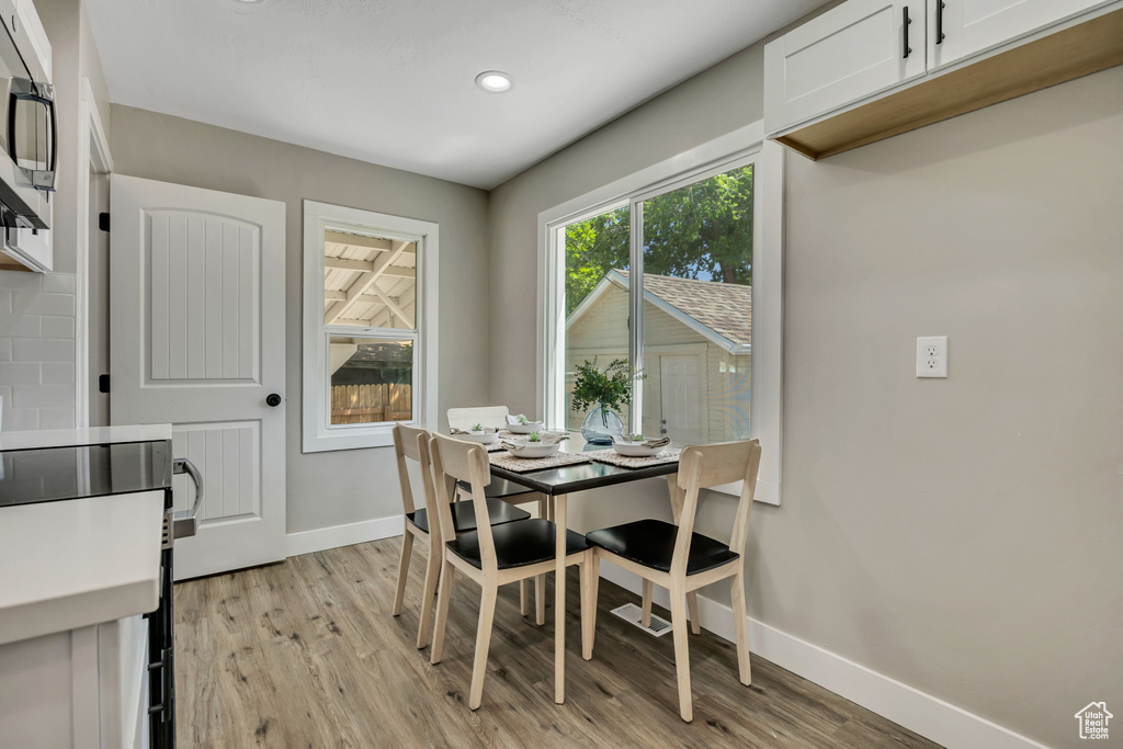 Dining room featuring baseboards, light wood-style floors, and recessed lighting