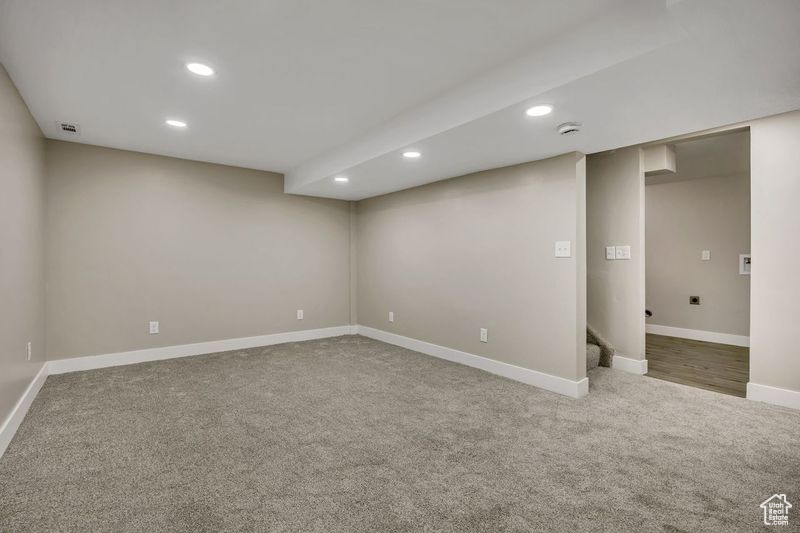 Finished below grade area with carpet, recessed lighting, baseboards, and stairway