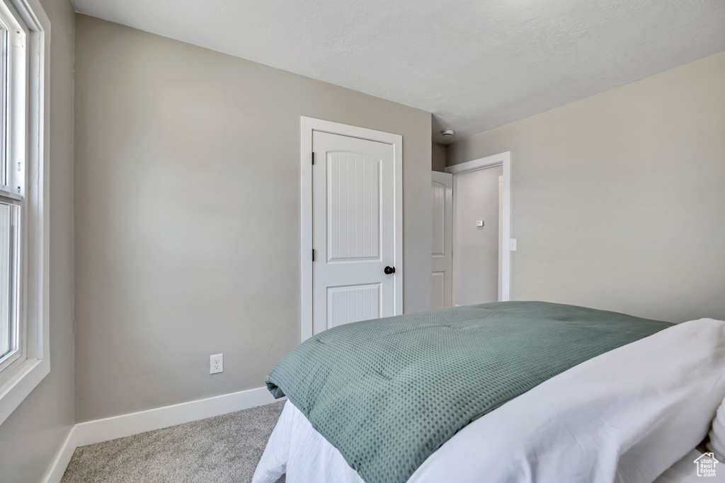 Bedroom featuring carpet and baseboards