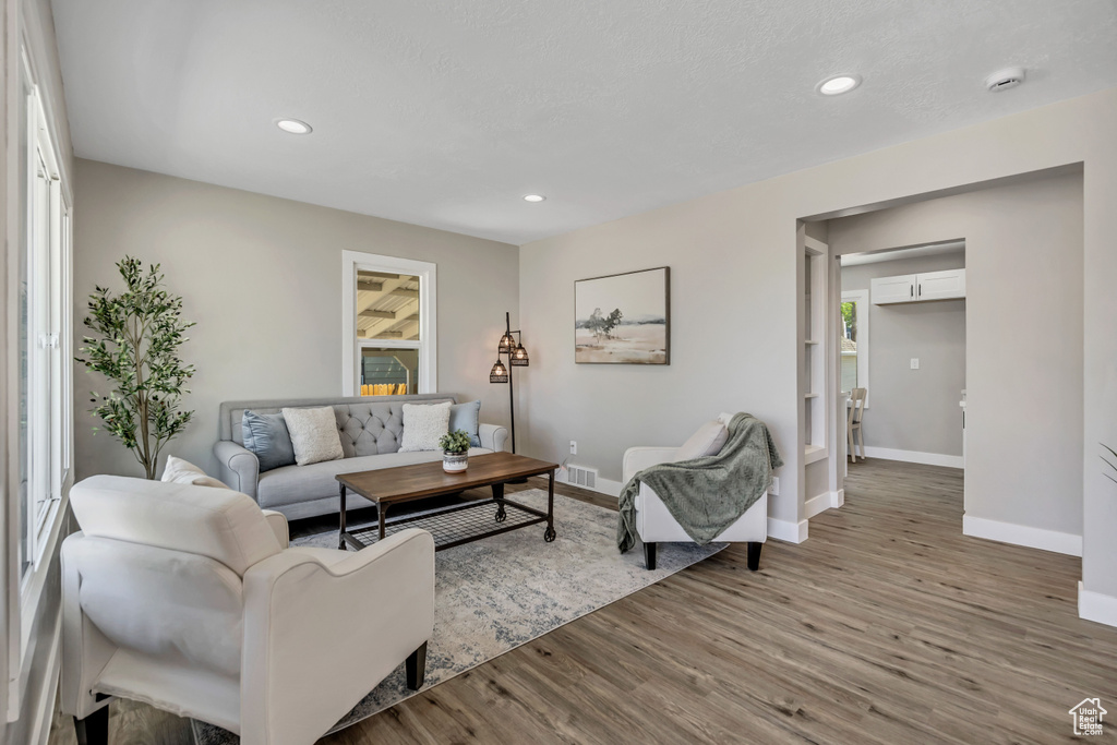 Living room featuring baseboards, wood finished floors, and recessed lighting