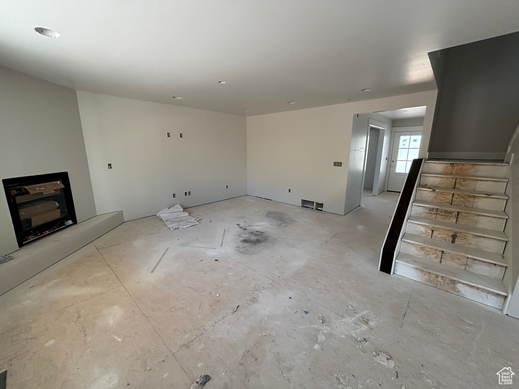 Unfurnished living room featuring stairs